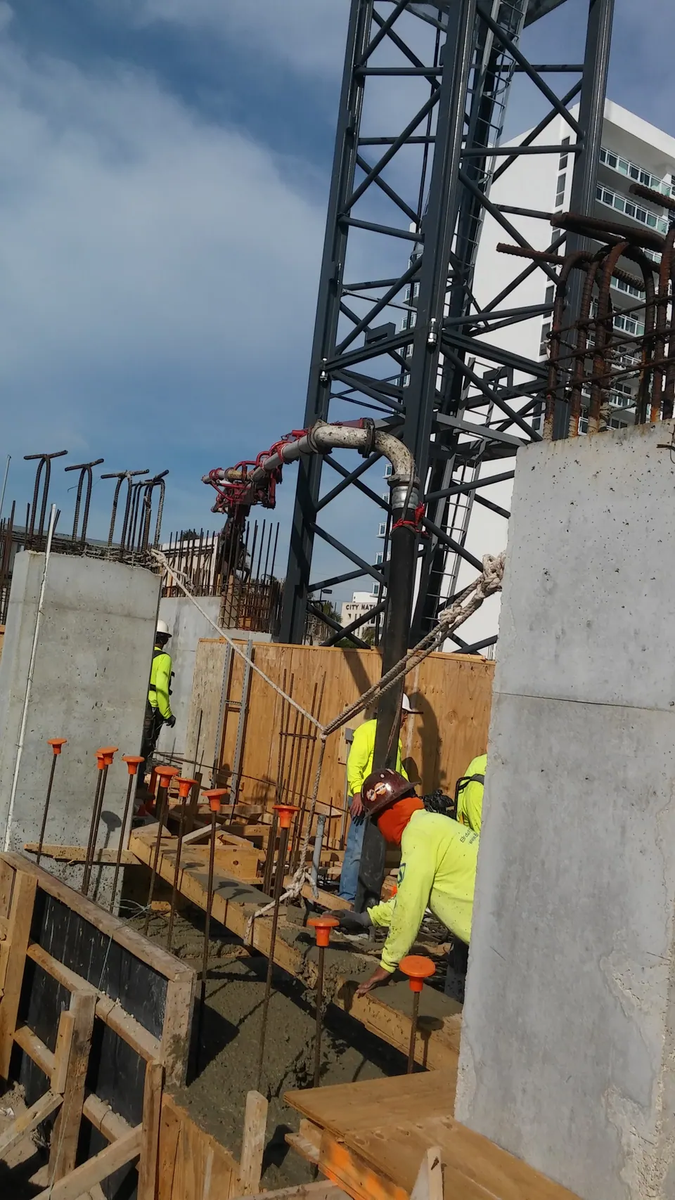 Crew guiding the hose on a concrete wall pour