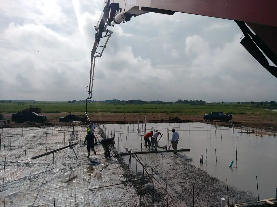 Crew finishing a slab pour placed by a boom pump